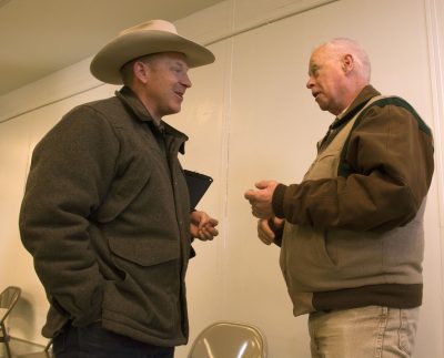 Two men are talking to each other in a hallway