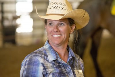 Woman wearing cowboy hat smiles