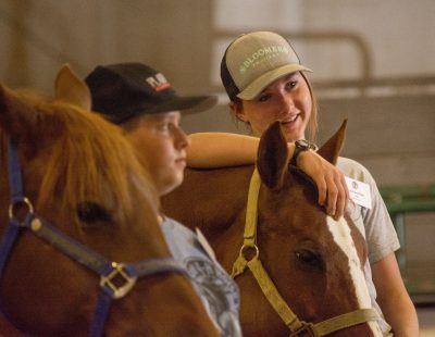 4-H'er leans her arm on horse