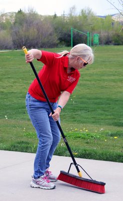 Beth Barker sweeps the sidewalk