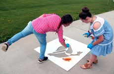 Two girls paint the duck stencil