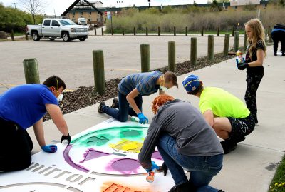 A group of boys paints the Mirror Me stencil