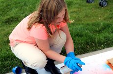 A girl paints the hopscotch stencil