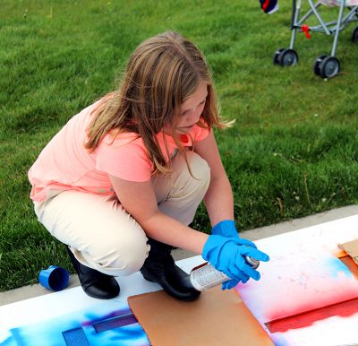 A girl paints the hopscotch stencil