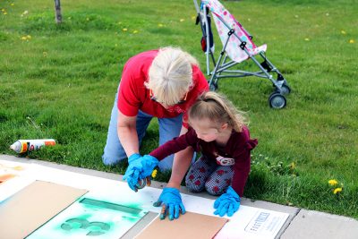 Beth Barker helps a girl with the paint.