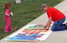 A father and daughter finish the hopscotch stencil