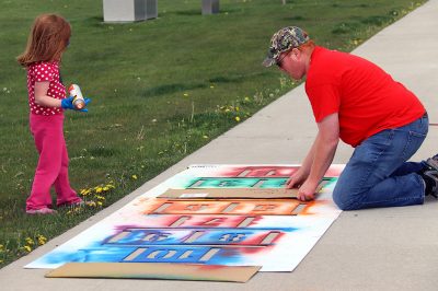 A father and daughter finish the hopscotch stencil