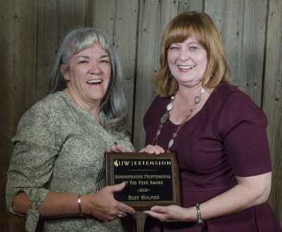 Two women hold a plaque