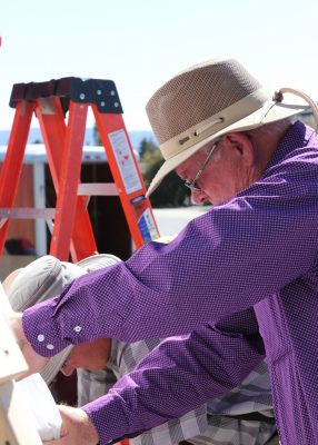 County Commissioner Bob King helps pull the sides tight while the plastic is pulled over the geodome frame. 