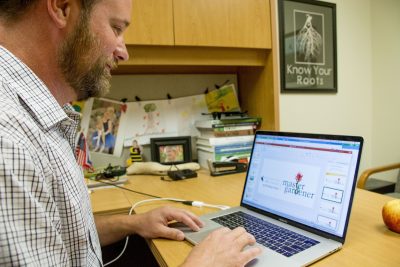 Photograph of person typing on computer