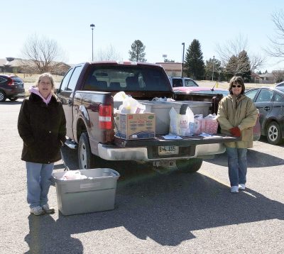 Photograph of two women beside pickup truck