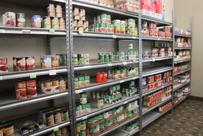 Metal shelving with organized cans of food.