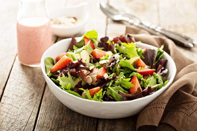 dressed salad in white bowl