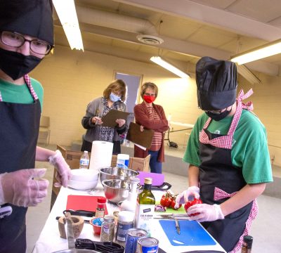 Photograph of 4-H'ers in masks preparing food