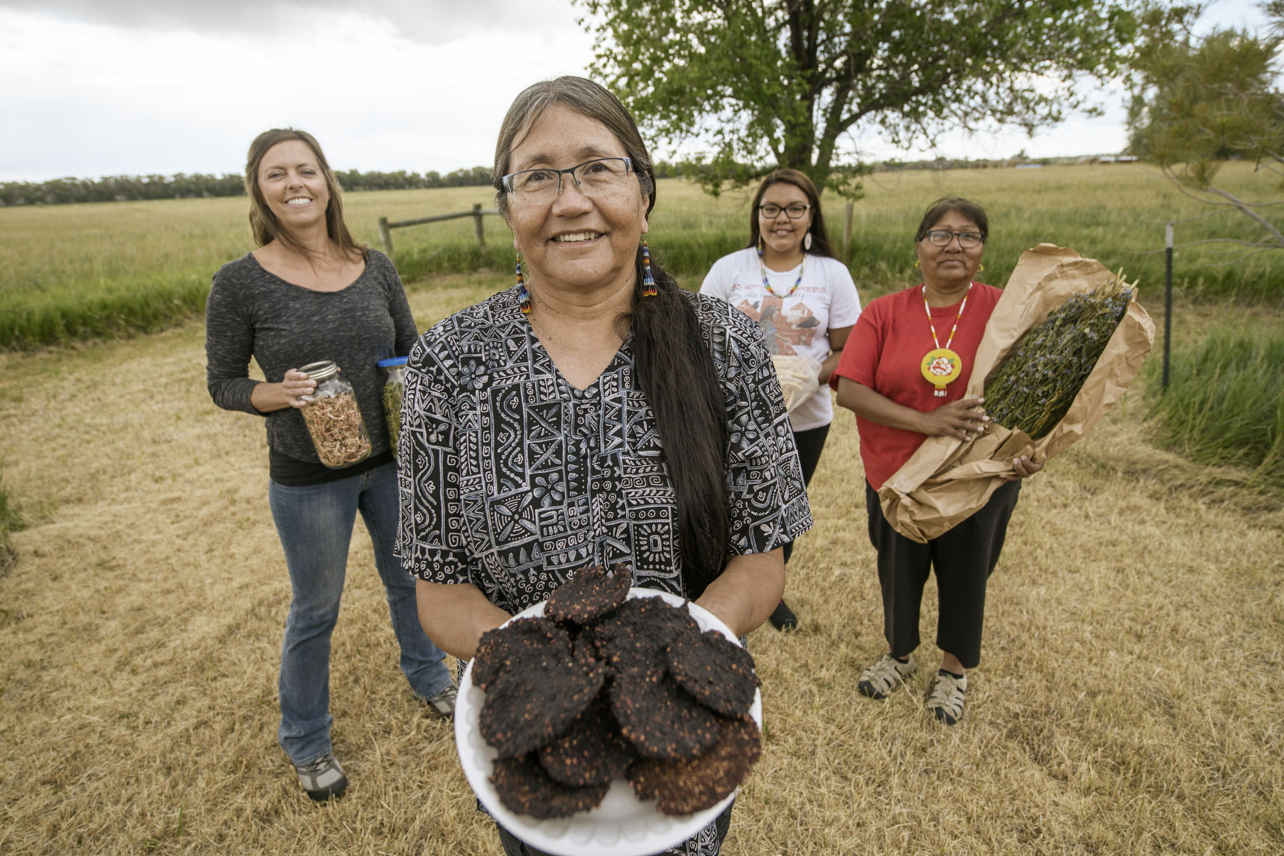 Four people holding different food items.