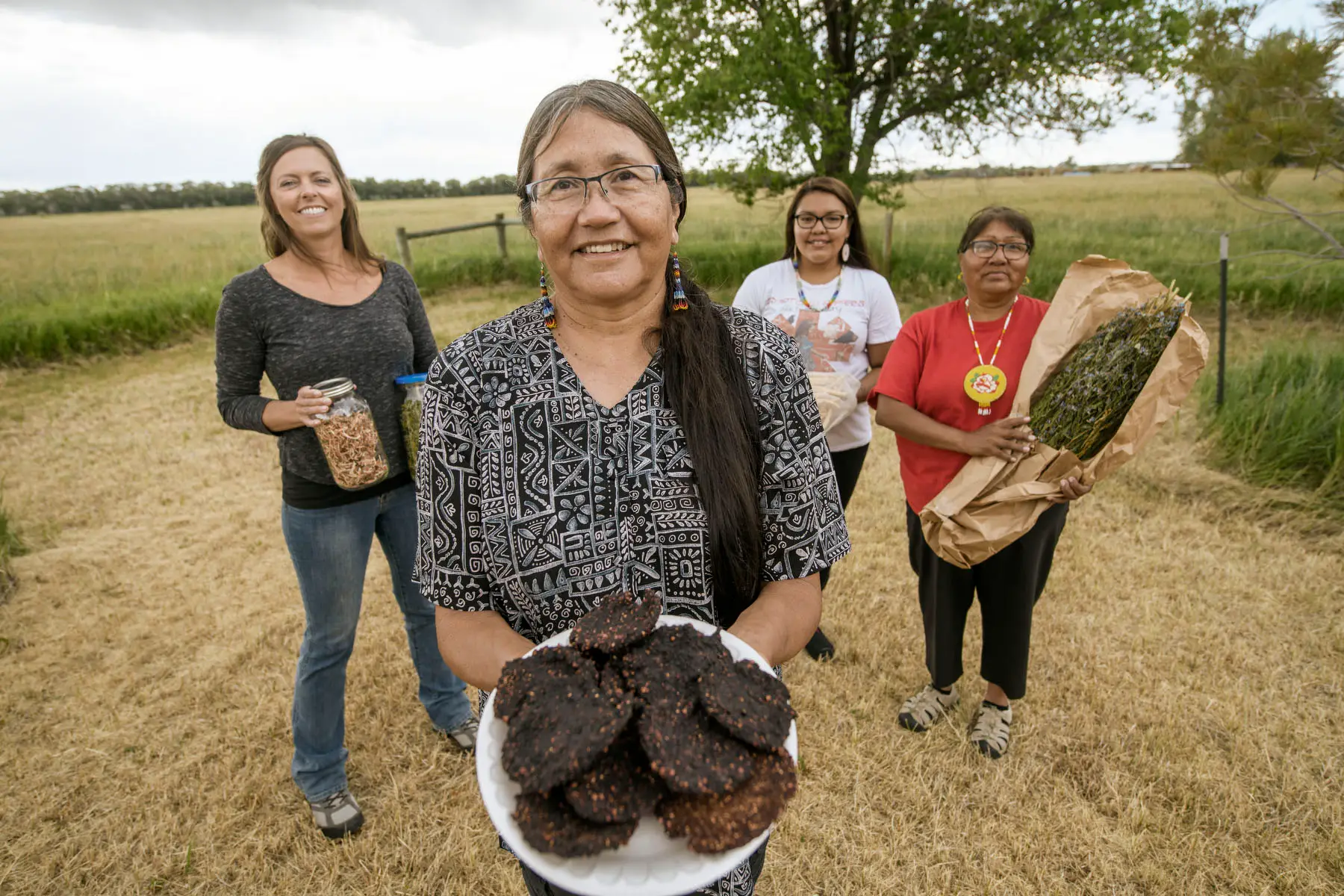 Four people holding different food items.