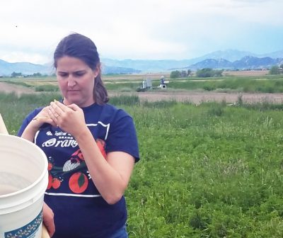 Photograph of student with alfalfa field in background