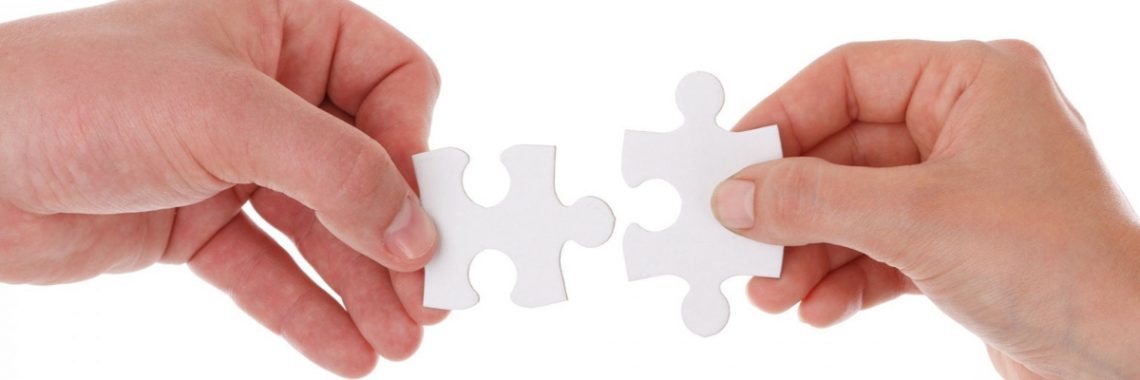 Hands putting two puzzle pieces together
