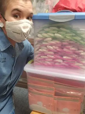 Individual with mask on next to tubes of mixes