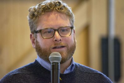 Man with glasses talking into microphone