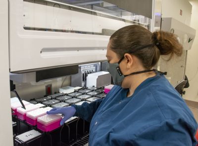 Woman sets samples into a machine