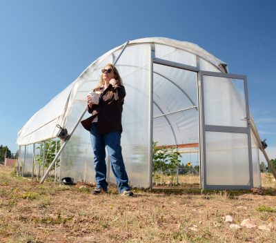 Lady standing near a hoop house