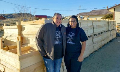 Two women in front of wooden boxes