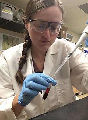 Student with syringe in laboratory