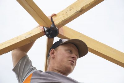 Man with hands on wooden supports