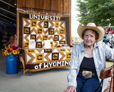 Woman seated in front of quilt