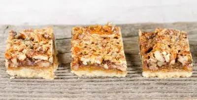 3 pecan bar cookies on wood plank
