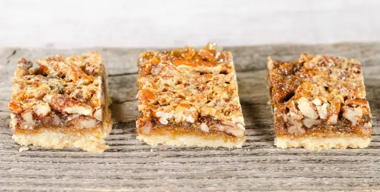 3 pecan bar cookies on wood plank