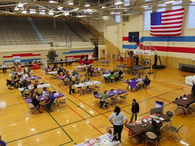 Tables with purple table cloths in a gym.