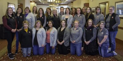 22 people pose for a group photo wearing Cent$ible Nutrition Program logo wear