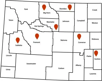 Map showing Wyoming's 23 counties with red location pins in Big Horn, Sheridan, Washakie, Sublette, Fremont, Converse, and Goshen