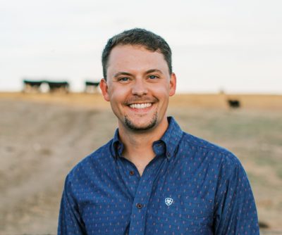 headshot of smiling man wearing blue shirt