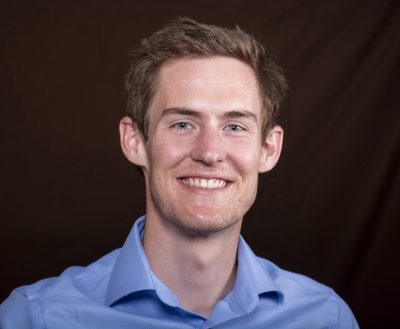 smiling man wearing light blue collared shirt