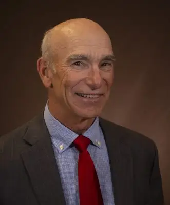 smiling man wearing red tie and suit jacket