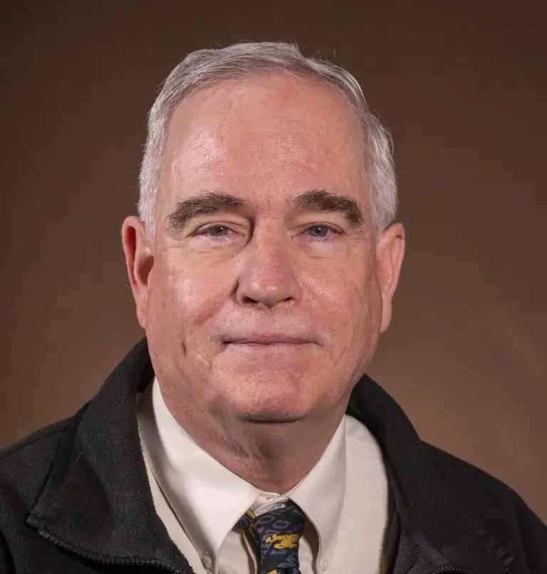 smiling gray-haired man wearing Wyoming cowboys tie
