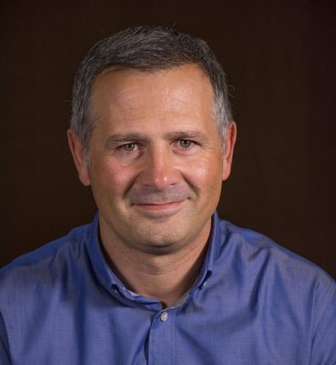 portrait of smiling man wearing blue collared shirt