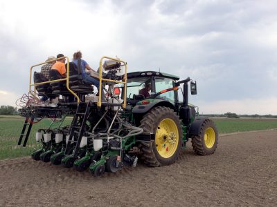 Green farm vehicle with 3 riders.