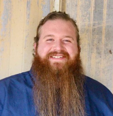 smiling man with long red beard wearing blue shirt