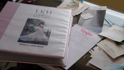 Pink binder with a photo of a woman in a wedding dress on the cover serves as the LKH Formal bridal look book
