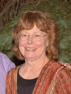 smiling woman with reddish hair and glasses wearing red jacket over black shirt