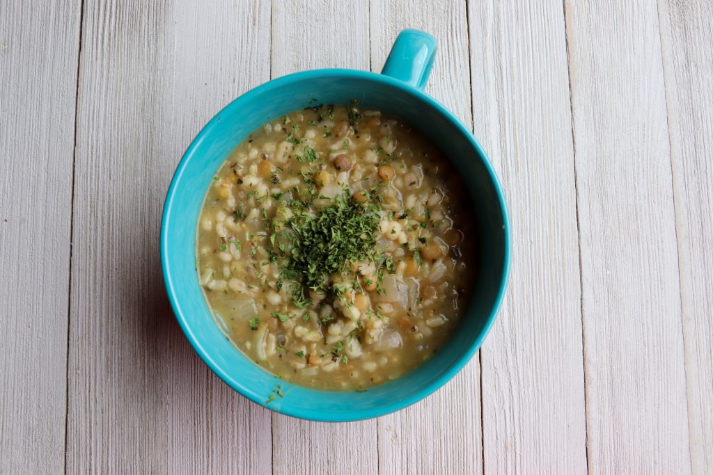 turquoise cup of soup made of lentils, split peas, rice, and barley