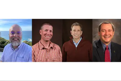 Four headshots of smiling white men. Left is bald with a graying beard and glasses; the background is ocean. Next to the right has cropped short hair and is wearing a checked orange polo shirt. Next to the right has short gray straight hair, a dark red sweater over a blue collared shirt. Final has short gray hair and is wearing a suit with a red tie.