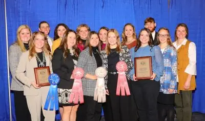 A group of young adults in formal clothing holding up two plaques and four ribbons.