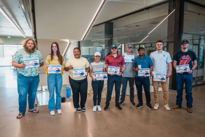 A group of students holding plaques that read, "INNOVATOR: Wyoming Innovation Partnership" along with the WIP logo, a colorful bison.