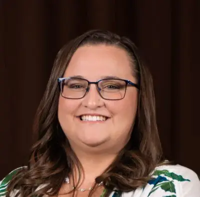 A woman with brown hair and glasses