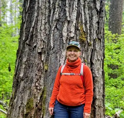 A woman in front of a large tree